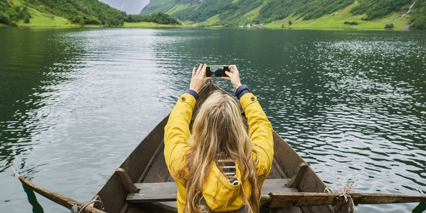 girl on boat taking a photograph