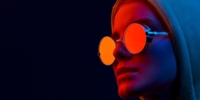 Yellow neon close up of woman in round sunglasses